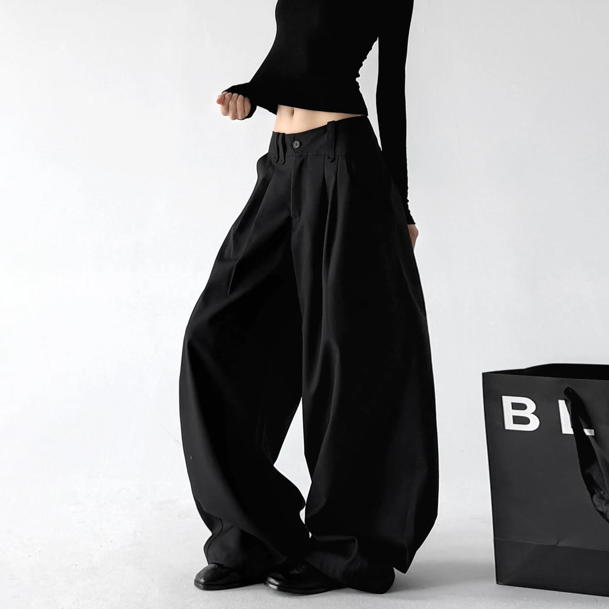 Black double pleat wide leg pants, angled front view