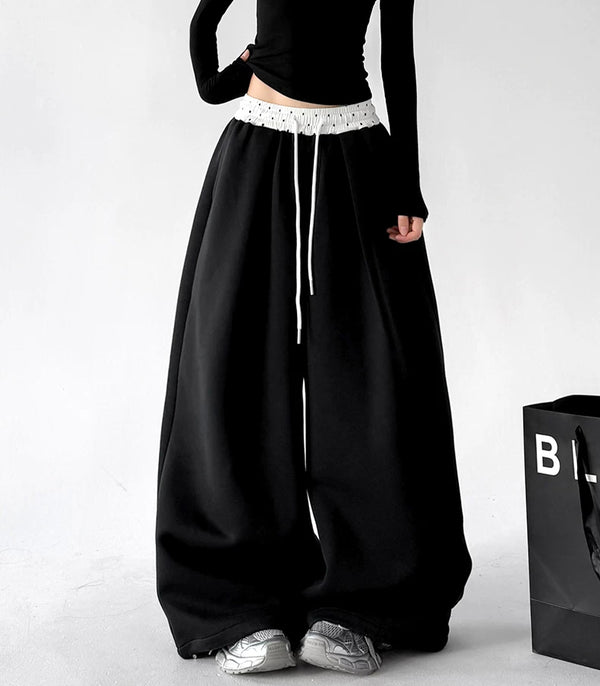 Black contrast waist wide leg pants, front hands view