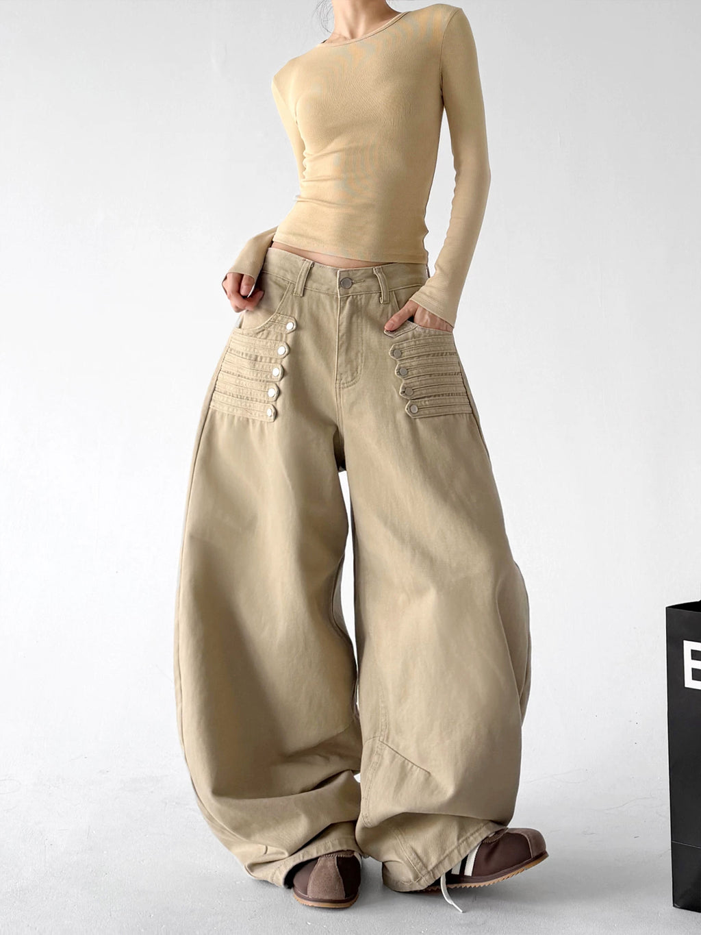Khaki wide-leg pants, front hands view.