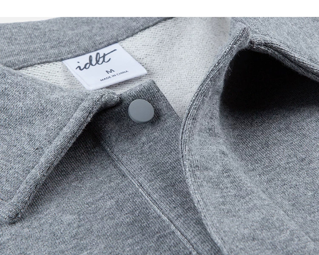 IDLT polo sweatshirt, heather gray open collar and snap fastener.