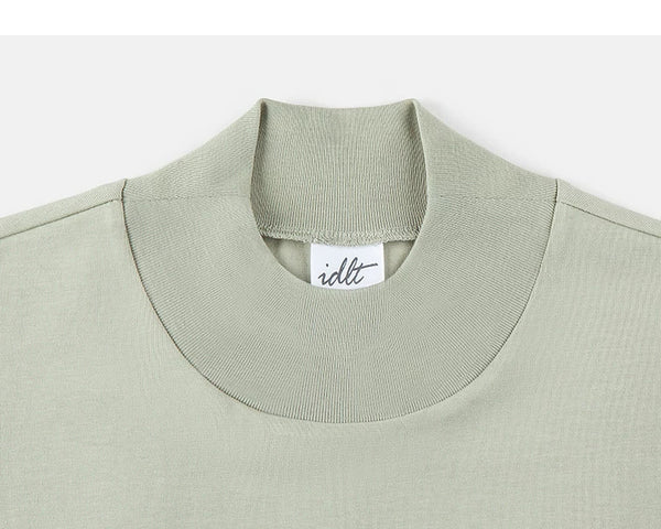 IDLT mock neck T-shirt, sage green collar.