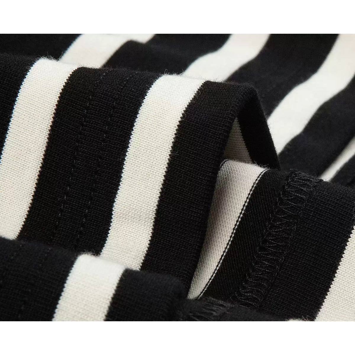 IDLT striped T-shirt, black and cream fabric folds close-up.